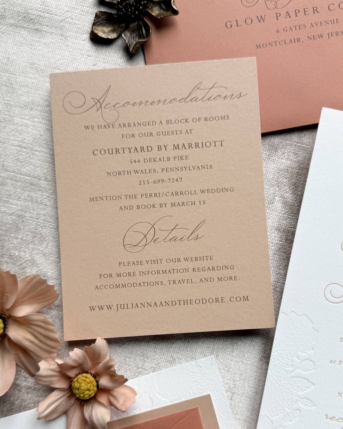 Wedding accommodation details card with flowers on a textured surface