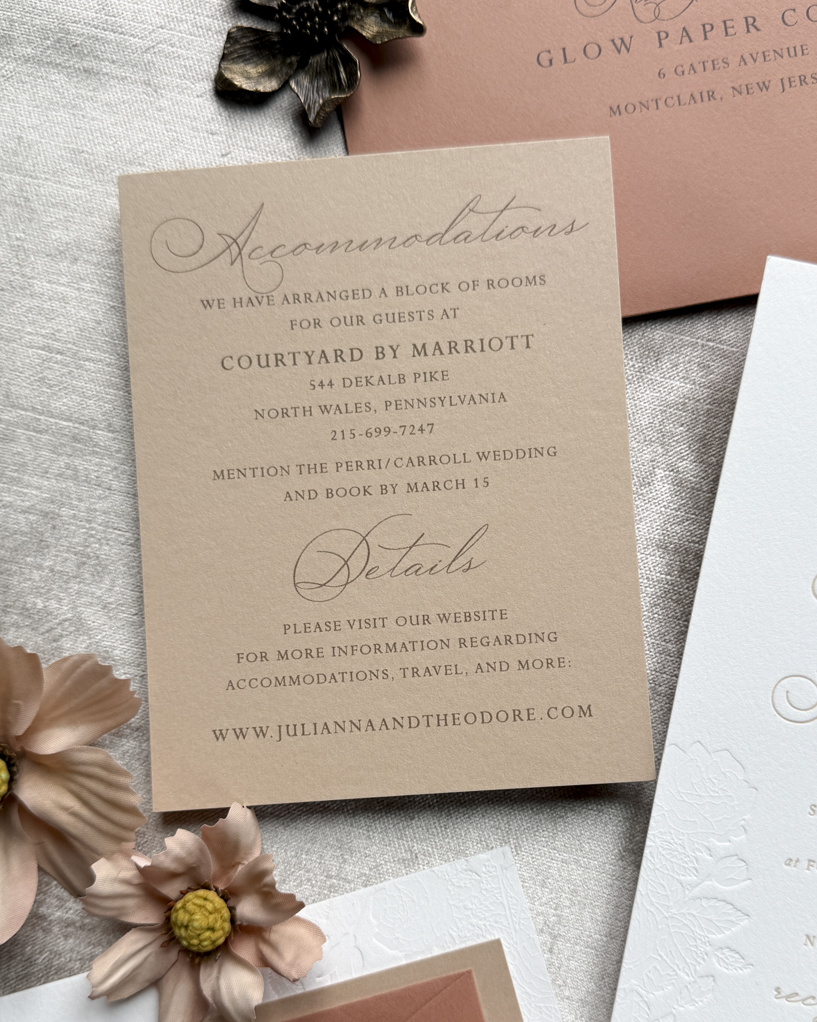 Wedding accommodation details card with flowers on a textured surface