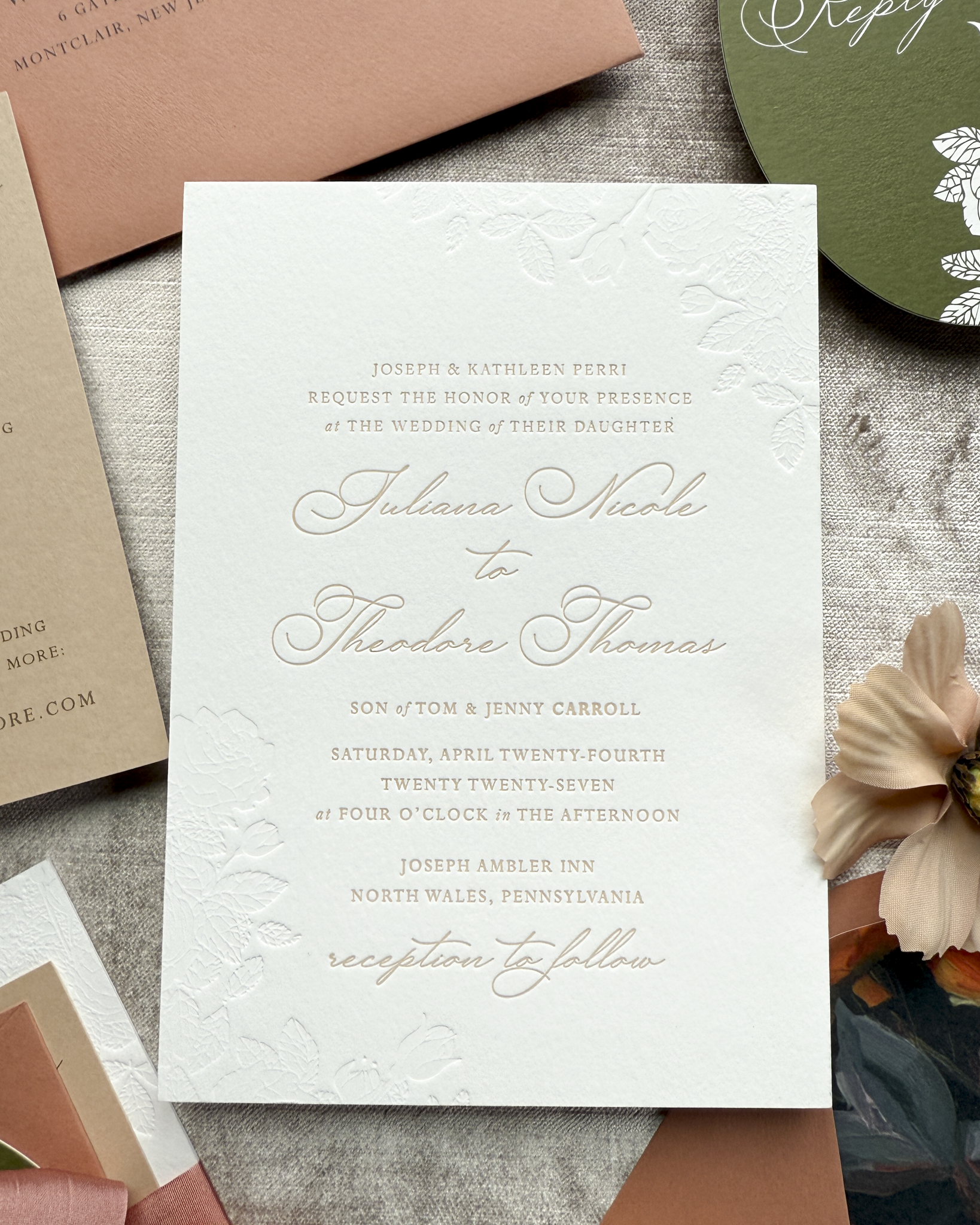Wedding invitation card with elegant text on a textured surface with envelopes and a flower.