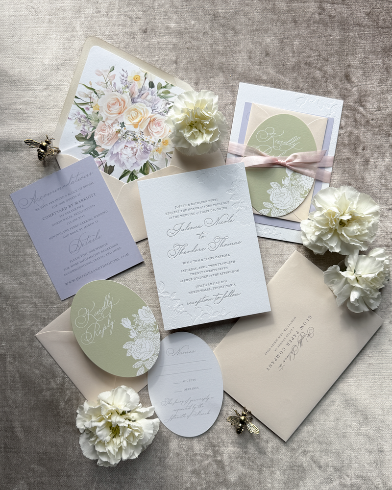 A springtime wedding invitation in pastel colors featuring a die cut insert and a floral envelope liner