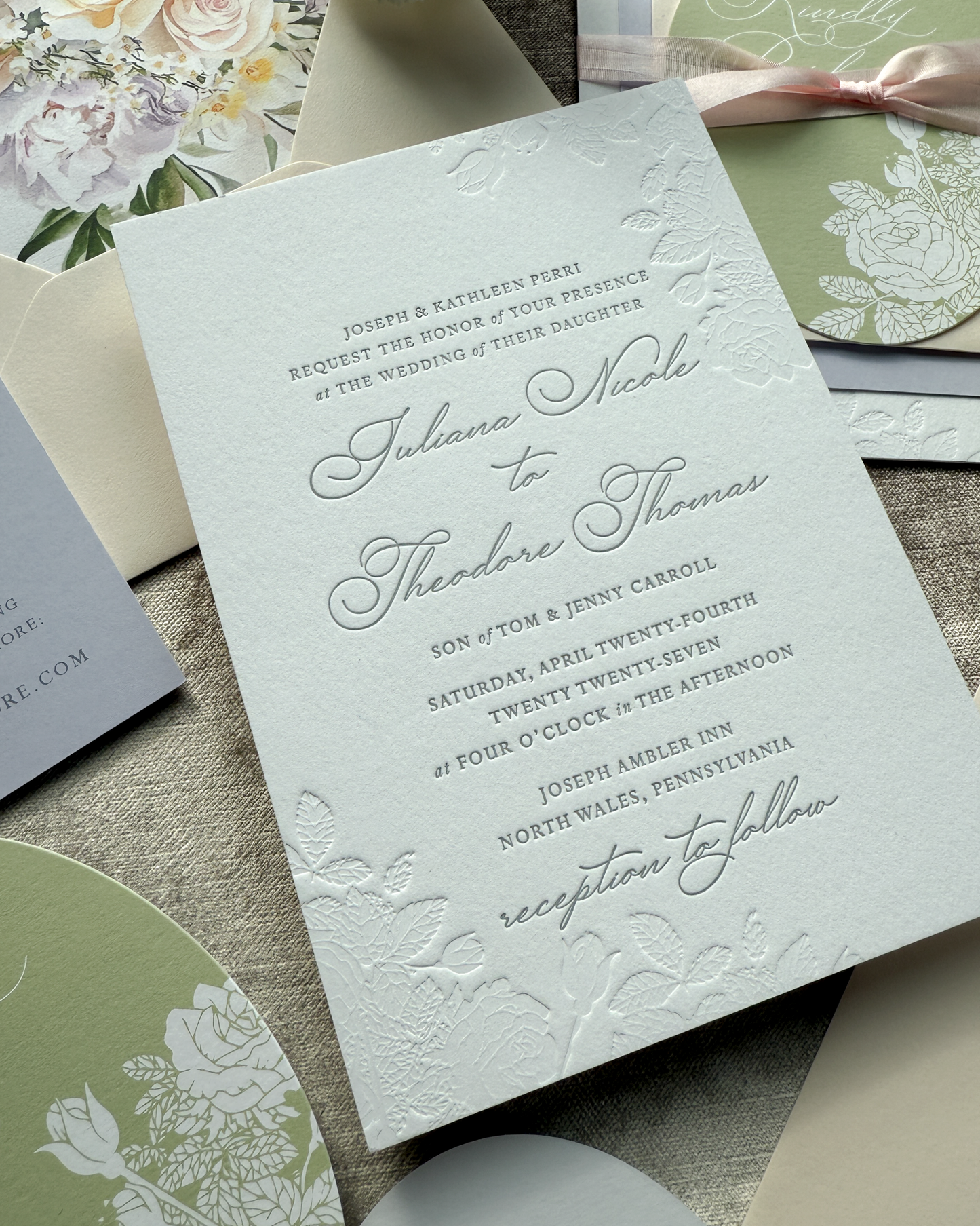 Detailed wedding invitation with floral designs on a textured surface