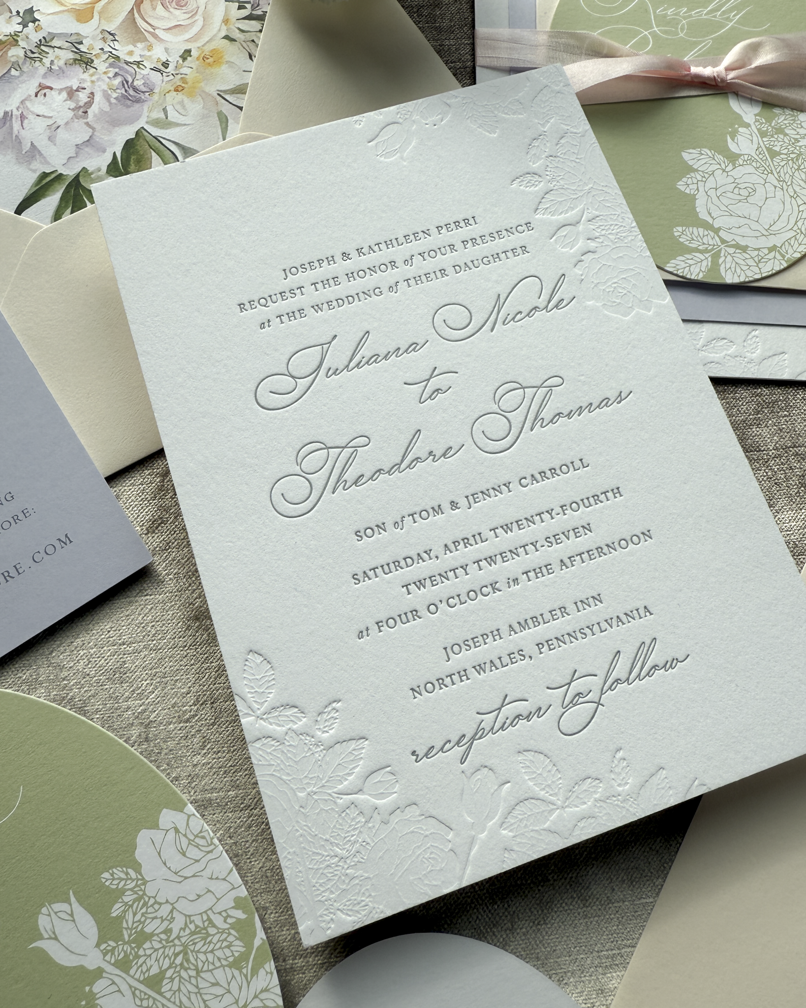 Detailed wedding invitation with floral designs on a textured surface