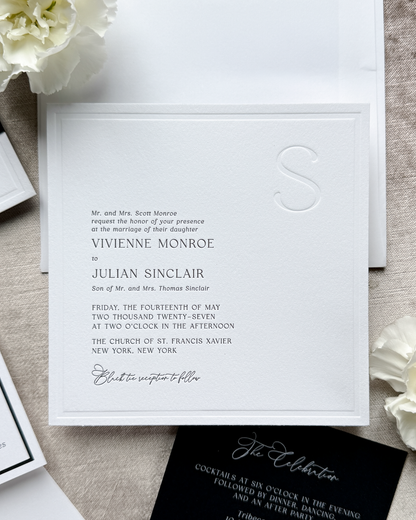 Wedding invitation card with floral decorations on a textured surface