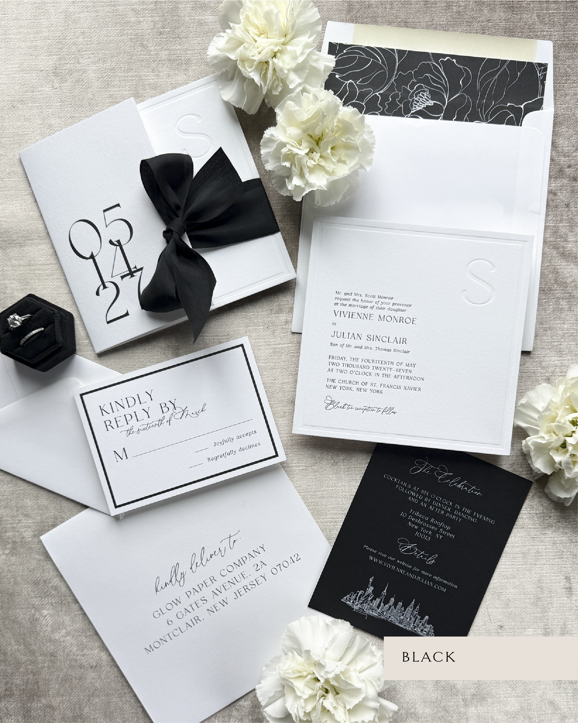 Black and white wedding invitation set with flowers on a textured surface