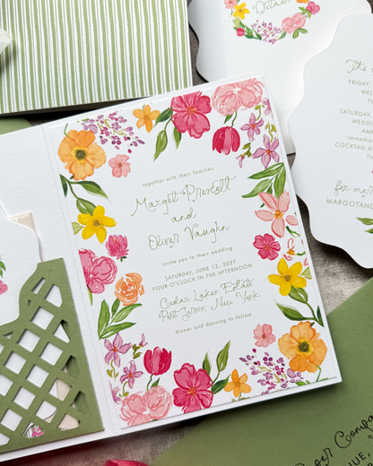 A wedding invitation with whimsical font and handpainted floral watercolor art in bright, bold colors