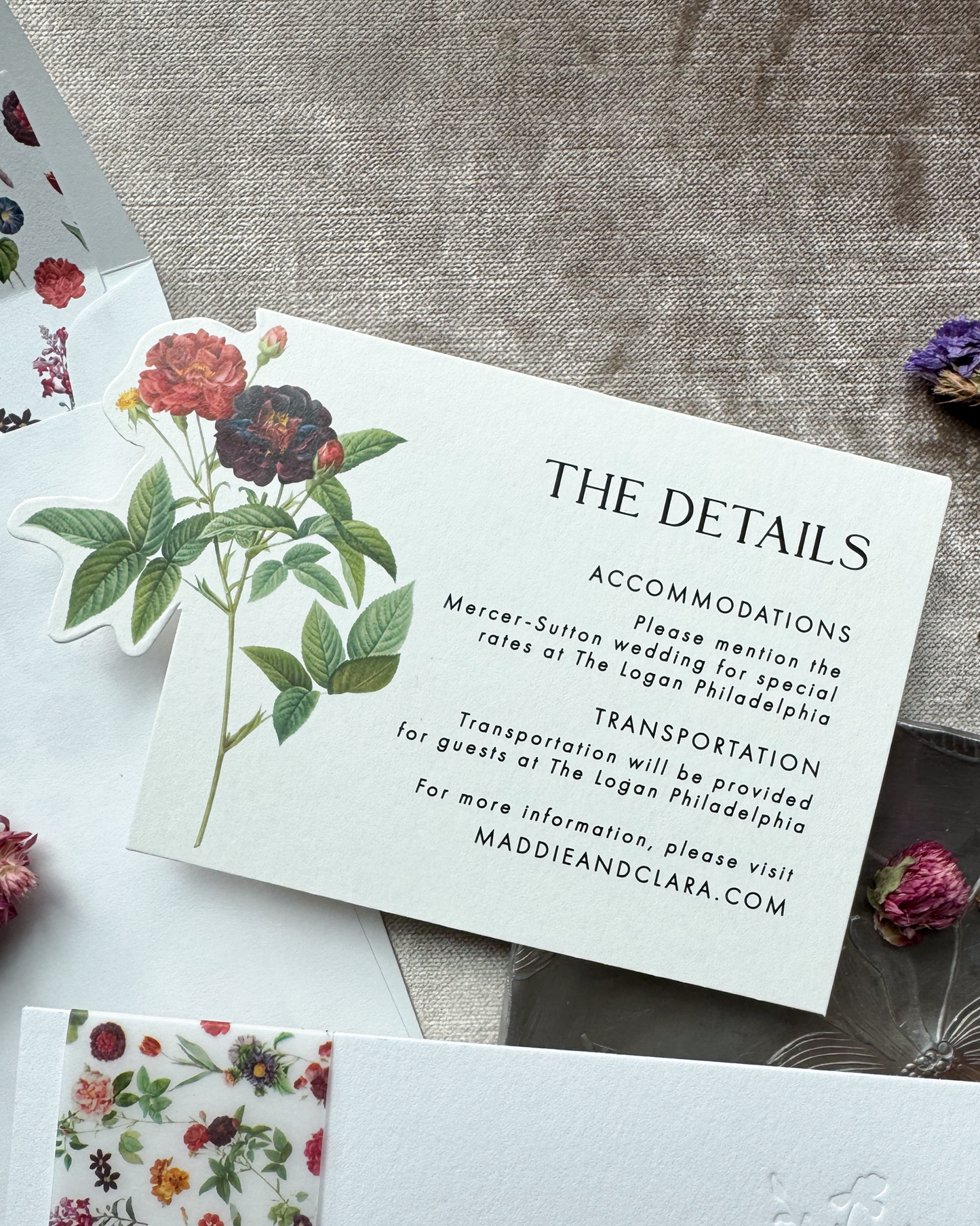 Wedding detail card with floral design on a textured surface