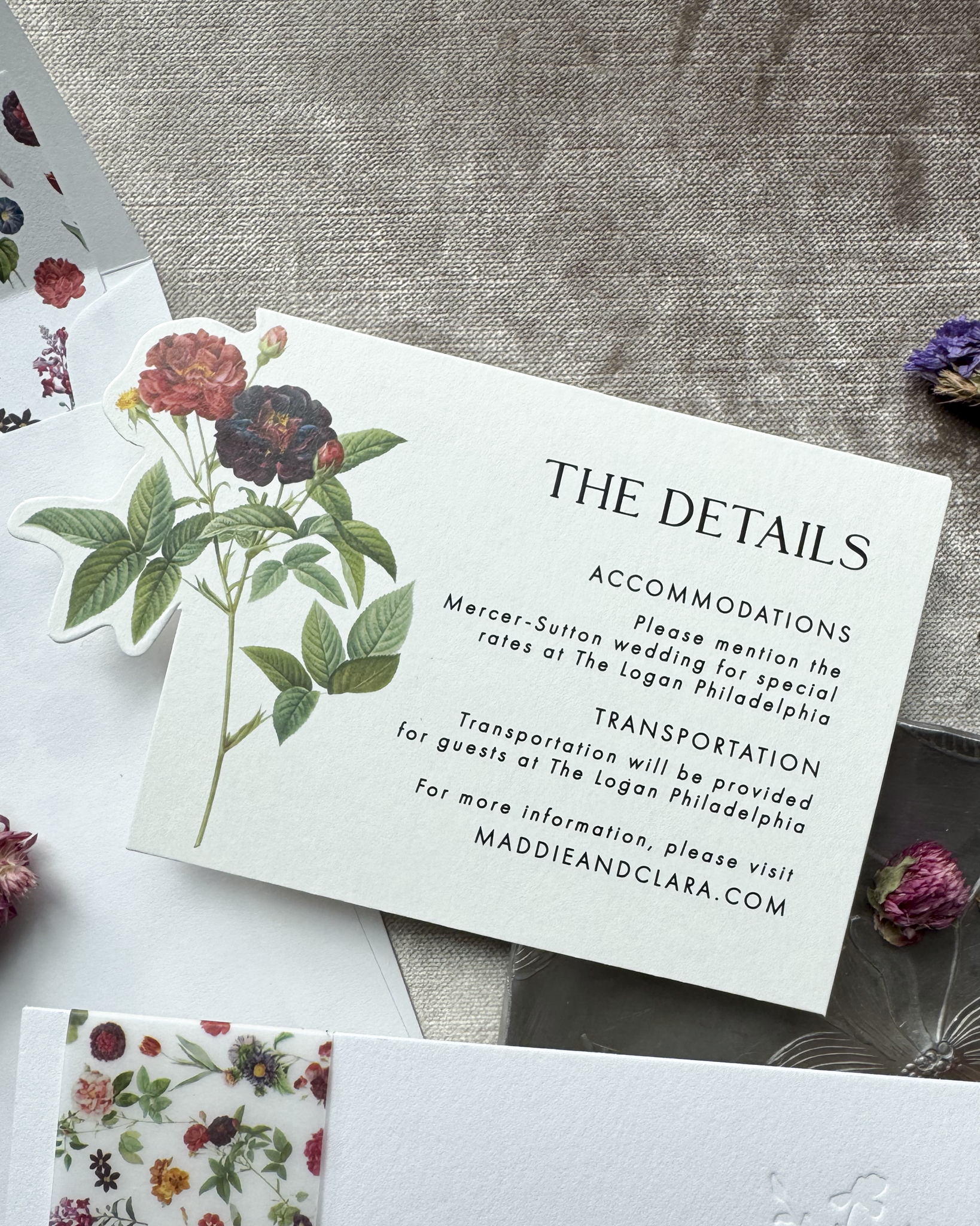 Wedding detail card with floral design on a textured surface