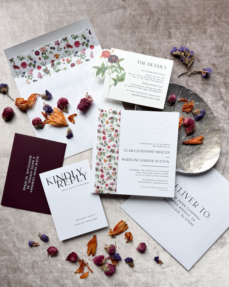 Stationery items including cards and envelopes with dried flowers on a textured surface